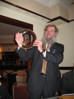 President John shows Onchan members the award received at the Rushen & Western Mann Charter Night.